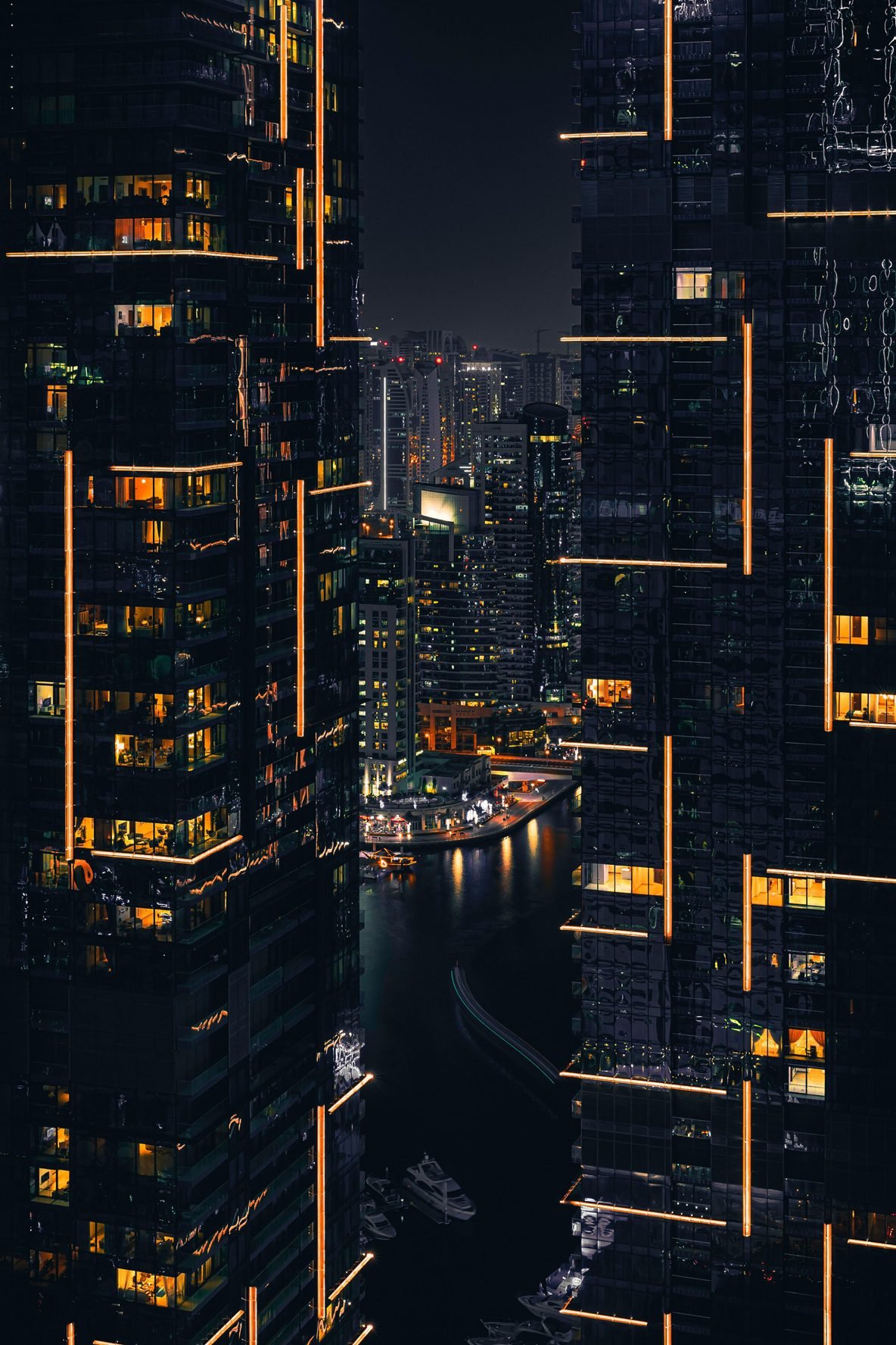 Dubai real estate market illustrated by high-rise residential towers overlooking a waterfront mixed-use district at night